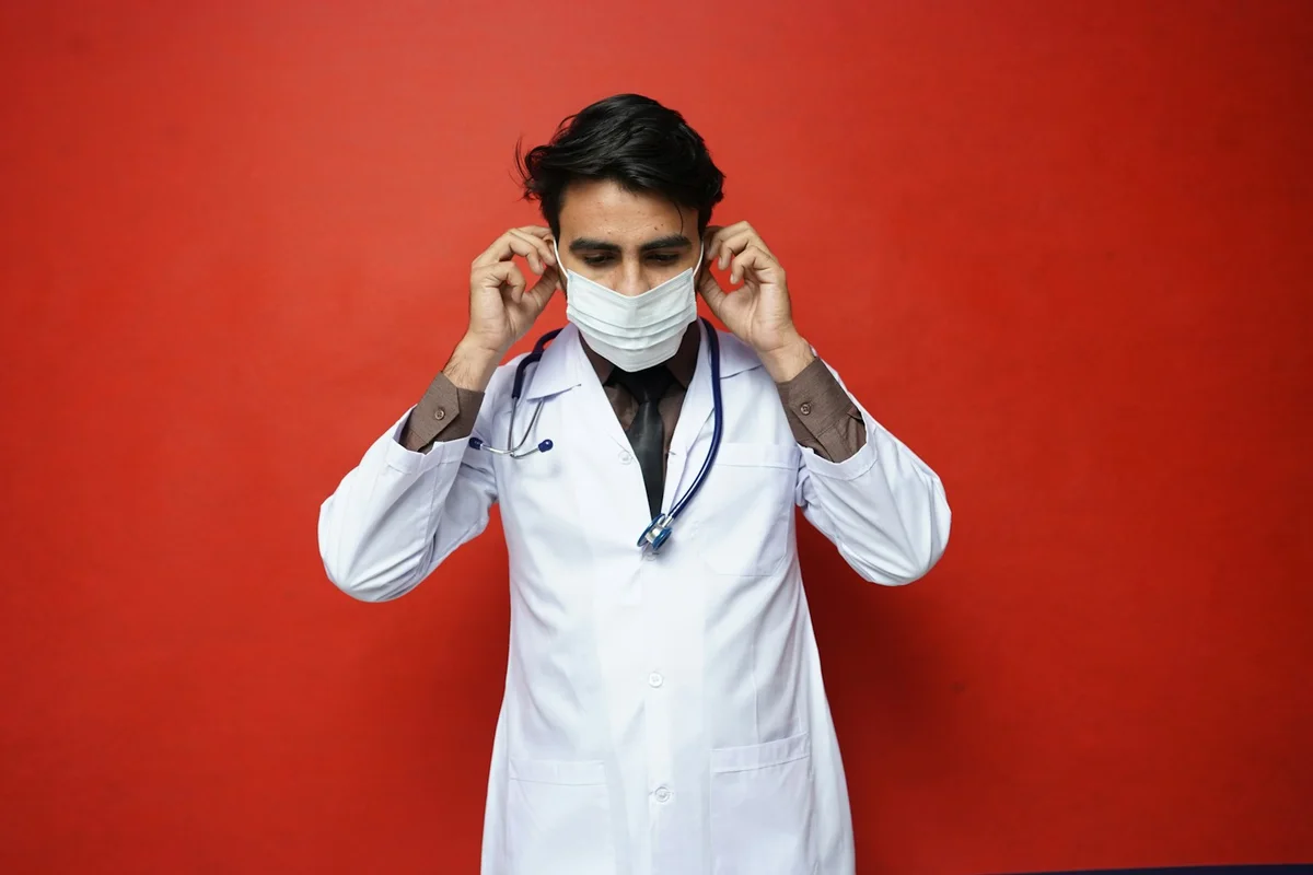 A medical worker adjusting a face mask